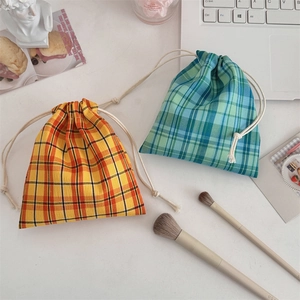 Flat lay of colorful checkered drawstring pouches for cosmetics and small accessories