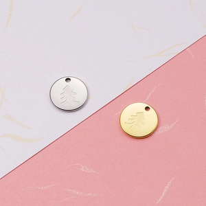 Detail of tree-etched 18K gold and silver mirror-finish stainless steel round pendants