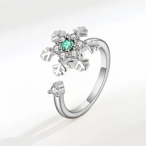 Detail of silver snowflake rotating ring with green gemstone and small white diamonds
