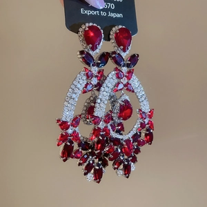 Detailed macro view of elegant tiered red crystal teardrop earrings with silver pins