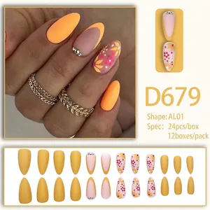 Chic long almond press-on nails with matte yellow floral designs and rhinestone accents