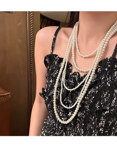 Detail of layered white glass pearl necklace in vintage Audrey Hepburn style on model