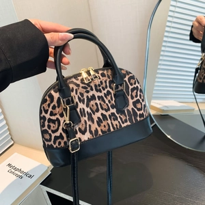 Minimalist leopard print shell bag with black leather handle and golden hardware details