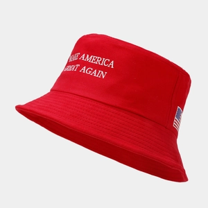 Détail du chapeau bob rouge en coton avec slogan brodé blanc et écusson drapeau américain