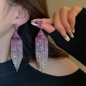 Macro shot of long purple gradient tassel earrings with shimmering rhinestone embellishments