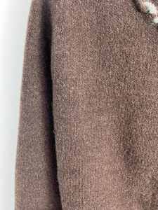 Gros plan sur la texture en maille marron foncé avec finition laineuse douce