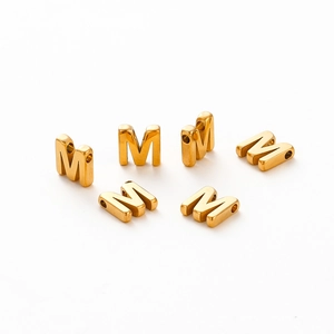 Macro shot of 18K gold plated letter M beads with 1.8mm hole for DIY jewelry making
