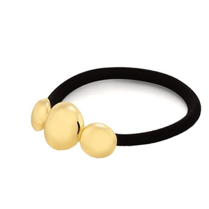 Detail of black elastic hair tie with three polished gold metal beads in a curved design