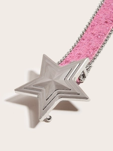 Macro shot of a pink sequin belt featuring a large gold star-shaped buckle and metallic trim