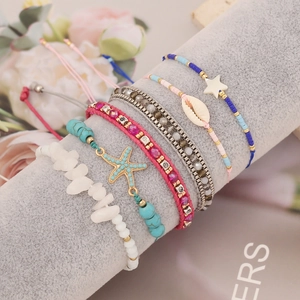 Bohemian braided bracelets with natural stones, starfish charms on a jewelry display