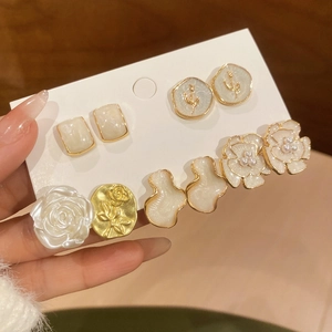 Vista dettagliata di eleganti orecchini vintage con fiori e perle in resina crema e oro