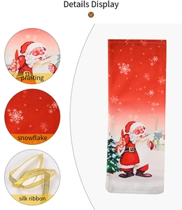Detailed close-up of Santa Claus print and golden ribbon on red Christmas wine bottle cover