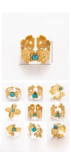 Detail view of gold stainless steel adjustable rings with floral motifs and tiger eye stones
