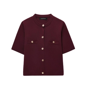 Detail of burgundy knit cardigan featuring gold embossed buttons and pocket accents