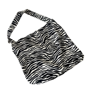 Zebra print canvas tote bag with wide shoulder strap shown at a 45-degree angle