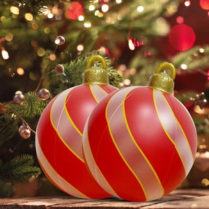 Detail of two inflatable Christmas balls with red and pink stripes on a wooden platform