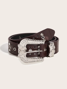 Detail of dark brown crocodile-textured belt with silver butterfly buckle and star studs
