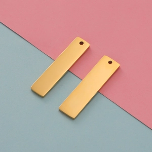 Detailed view of two polished gold-plated stainless steel rectangular pendant tags