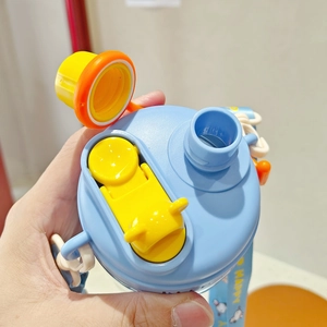 Macro detail of the blue and yellow dual-drink straw lid with secure locking mechanism