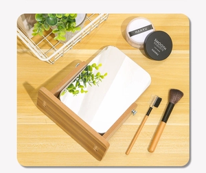 Close-up of a rectangular wooden desktop makeup mirror with adjustable rotation feature