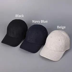 Three minimalist linen baseball caps in black, navy, and beige on a grey background