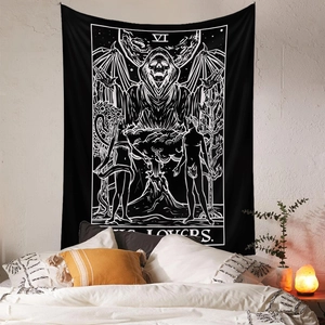 Detail of The Lovers tarot tapestry hanging above a bed with cozy warm lighting