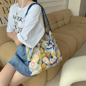 Artistic oil painting floral tote bag shown on shoulder in a cozy home setting