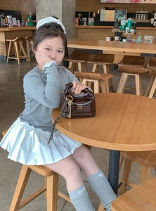 Girl's dark brown glossy hand bag shown with minimalist school outfit style