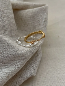 Detail of silver heart rings with tiny cubic zirconia on textured beige fabric cloth