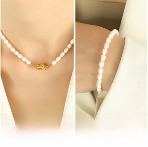 Detail of freshwater pearl necklace and bracelet set with golden pea-shaped clasp on model