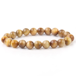 Macro shot of natural yellow tiger eye beaded bracelet showing silk luster and cat eye effect