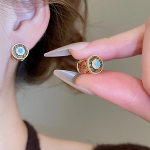 Detail von 18K vergoldeten Ohrringen mit Türkis-Zentrum und Muscheltextur-Halo