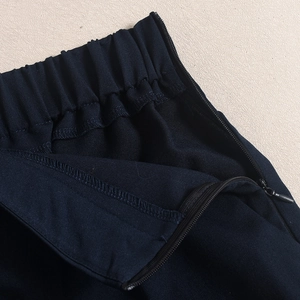 Dettaglio macro della vita dei pantaloncini blu navy con zip invisibile e cuciture