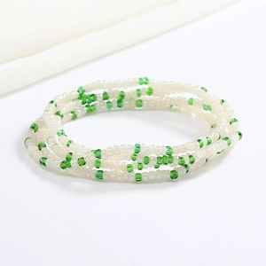 Detail of green and pearl white beaded body chain made of small elastic glass seed beads