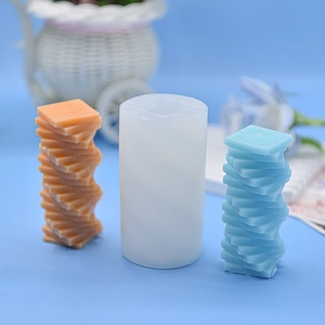 Detailed view of flexible silicone mold with spiral stacked cube candles in blue and orange