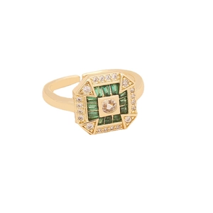 Golden open ring set with emerald green zircon and white crystal details on gray background
