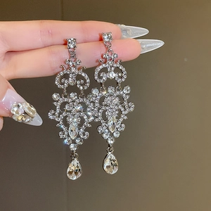 Detail of luxury teardrop chandelier earrings with sparkling rhinestones and silver finish