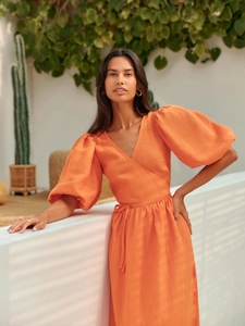 Detailaufnahme des orangefarbenen Baumwoll-Wickelkleides mit Puffärmeln und V-Ausschnitt