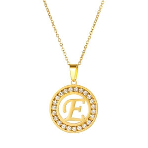 Macro detail of gold stainless steel necklace with sparkling E letter pendant
