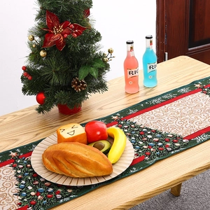 Christmas table runner with jacquard holiday patterns displayed on a wooden table setup