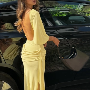 Detail view of the backless design and pleated texture on this yellow maxi dress