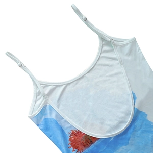 Detail of adjustable thin straps and floral pattern on a white summer dress