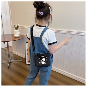 Back view of a black canvas toddler crossbody bag with cute white rabbit print
