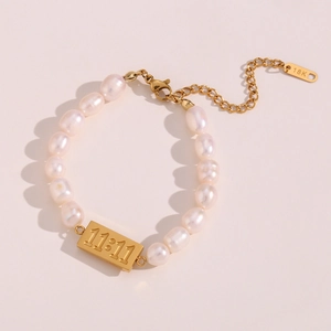 Detail of 11:11 gold square plaque on fresh water pearl bracelet with lobster clasp