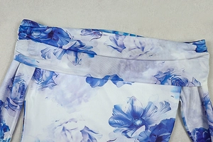 Detail of blue floral print off-shoulder neckline with elegant pleated fabric texture