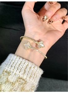 Close-up of 18k gold plated iris open bangle with mother of pearl and zircon stones