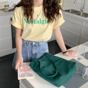 Deep green washed cotton tote bag placed on a kitchen table with lifestyle setting