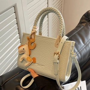 Sac seau vert menthe avec gaufrage crocodile, poignée tressée et breloque en cheval