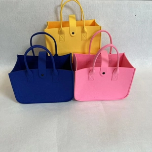 Detailed view of colorful felt tote bags with metal button closure in a stacked layout