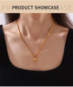 Detail of 18k gold plated snake chain necklace with zircon round pendant on model